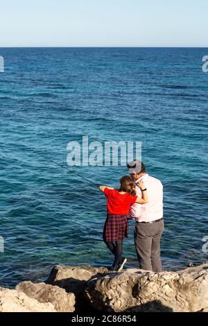 Father and daughter fishing in Zakynthos, Greece Stock Photo