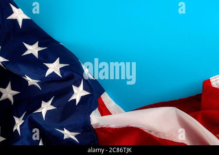 United States of America and American patriotism concept with close up on the the USA star and stripes flag with copy space on blue blank paper Stock Photo