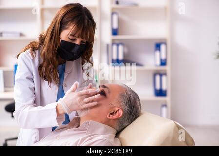 Old man visiting female doctor for plastic surgery Stock Photo