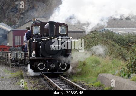 'Merddin Emrys' brings a slate train out of Boston Lodge Yard and onto The Cob. Stock Photo