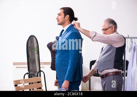 Young businessman visiting old tailor Stock Photo