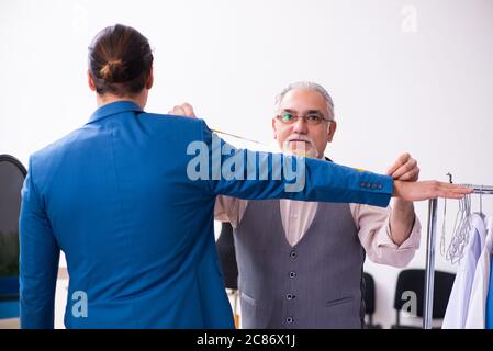 Young businessman visiting old tailor Stock Photo