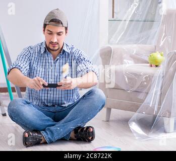 The young man contractor choosing color from rainbow Stock Photo