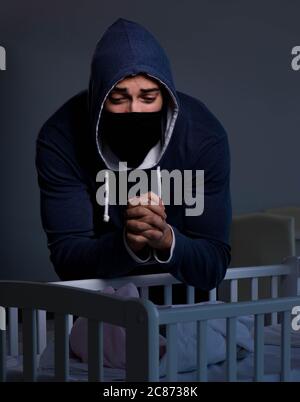 The criminal stealing baby in human child traficking concept Stock Photo