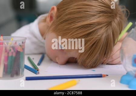 Five years old boy with tablet and drawing tools. Distance online education with digital tablet and notebook tired from  doing school homework. Stock Photo