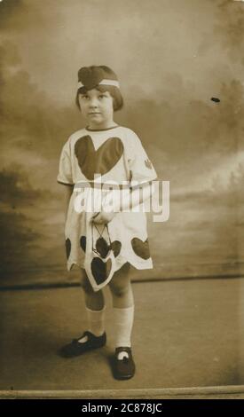 Delightful photograph of a little girl called Margaret dressed in a costume embellished with love hearts. Stock Photo
