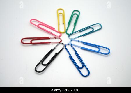 Rainbow color paperclips arranged in a star asterisk shape Stock Photo