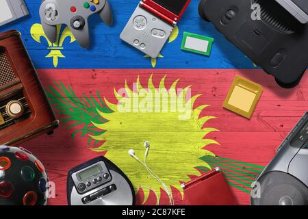 Guadeloupe retro gaming concept. A collection of retro video game controllers shot from above on a national background. Stock Photo