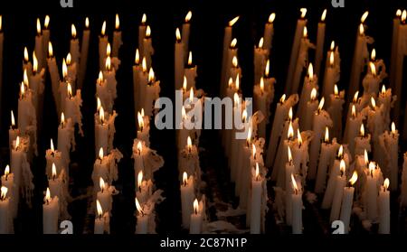 A group of nine burning wax candles with a black background Stock Photo ...