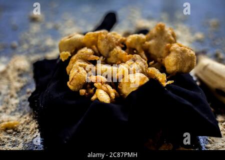 The famous shot of banana bhajia in a black colored container along with some raw banana and spices that are needed to make it. Stock Photo