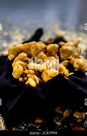 The famous shot of banana bhajia in a black colored container along with some raw banana and spices that are needed to make it. Stock Photo