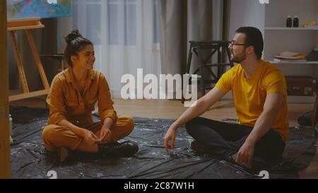 Couple of artists talking with each other in art studio. Stock Photo