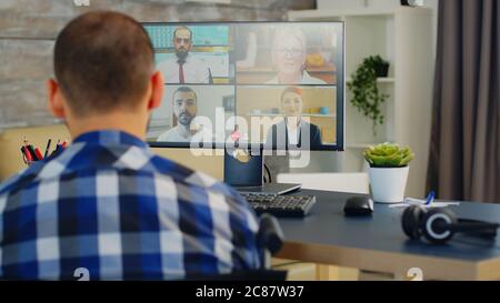 Businessman in wheelchair waving during a video call with business partners. Stock Photo