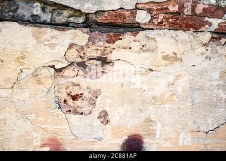 Abstract background of old dirty faded cracked white wall with aged bricks Stock Photo