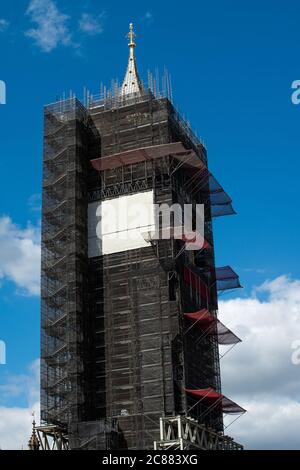 View of Big Ben covered with scaffolding against a blue sky with clouds, Restoration work on Big Ben began in 2017 and is due to be complete in 2021. Stock Photo