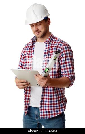 handyman worker in hard hat reads details of an order. builder in shirt with builder level and clipboard isolated on white studio background Stock Photo