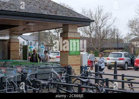 Entrance area to a well known British supermarket chain, showing a nearby bike rack and a disabled parking sign near to the entrance. Stock Photo