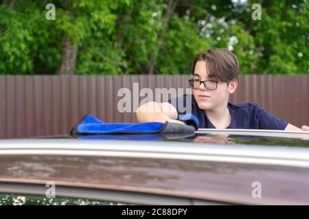 young guy washes a car with a rag. self wash machine Stock Photo