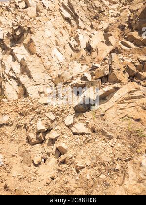 Natural background. Closeup edged shabby cliff cracks. Gray-brown stone rock texture of mountains. Vintage and faded matt style colour in tinted photo Stock Photo