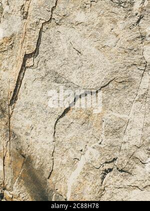 Natural background. Closeup edged shabby cliff cracks. Gray-brown stone rock texture of mountains. Vintage and faded matt style colour in tinted photo Stock Photo