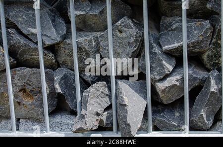 Natural stones in a gabion fence. Everything in close-up. Stock Photo