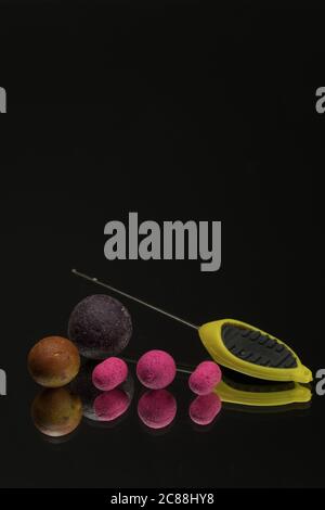bright green, red boilies, fishing baits for carp isolated on dark background. Stock Photo