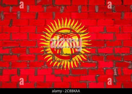 The national flag of Kyrgyzstan painted on a wall of sibit blocks with cement . The symbol of the country. Stock Photo