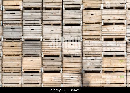 Wooden fruit boxes stacked on top of each other. Fruit containers prepared before harvest. Stock Photo