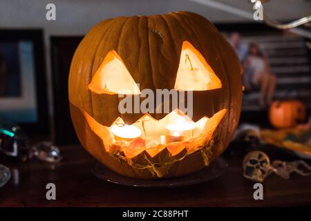 Jack-o'-lantern (dribbling). Beautiful fresh carved pumpkin close up lighten with candles. Typical scary halloween decoration, october 31. Stock Photo
