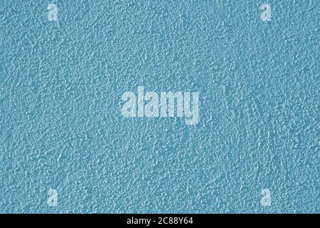 A low-contrast, blue plaster wall with a rough surface, an abstract background image for design creativity. Low contrast light-blue backdrop. Stock Photo