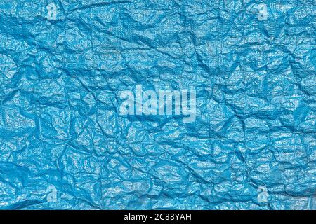 Plastic texture of blue polypropylene fabric for use in construction works, made of braided synthetic threads. Stock Photo