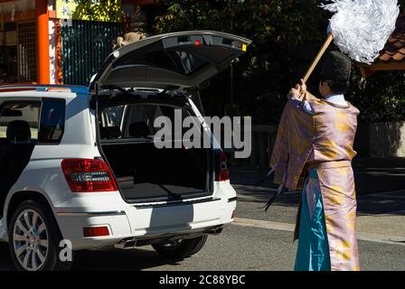 Japanese Shinto priest blessing a new car at Ikuta Shrine, Kobe, Japan Stock Photo
