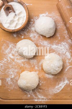 Freshly prepared yeast dough for pizza or bread on wooden background. Home cooking concept. Stock Photo