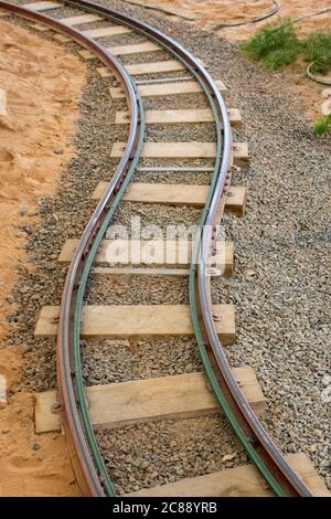 Twisted Railway track at an amusement park symbolizing moving ahead in business and life, travel and train concepts. Stock Photo