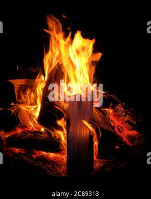 A bonfire with logs of wood burning in the night. Seen in Germany in July. Stock Photo