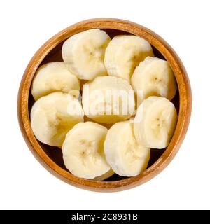 Fresh banana slices in wooden bowl. Ripe and peeled banana cut into round pieces. Edible and ready to eat dessert fruit with slightly yellow color. Stock Photo