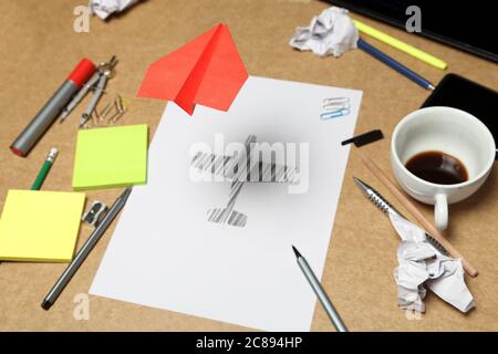 red paper plane flying over office desk, sketch of plane underneath, creativity concept Stock Photo