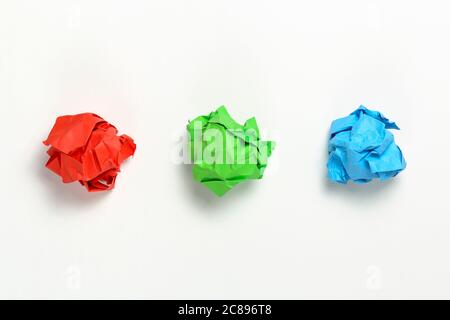 red, green and blue crumpled paper balls on white surface Stock Photo