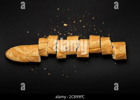 top view of sliced baguette on black Stock Photo