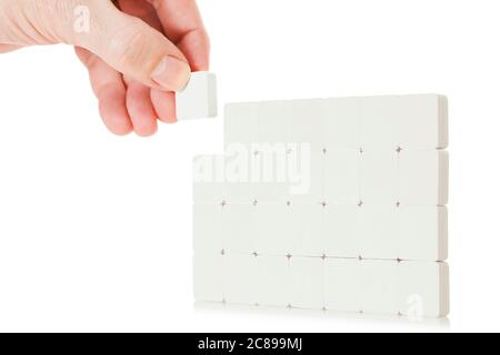 hand building a board with small blocks isolated on white Stock Photo