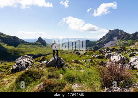 Woman standing on a rock in mountain landscape in National Park Durmitor, Montenegro Stock Photo