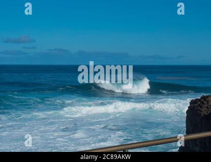 BIg crushing white wave over the Atlantic Ocean seen from terrace at la Fajana, La Palma, Canary Islands, Spain. Blue sky background. Stock Photo