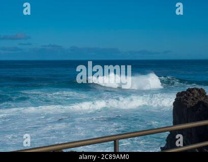 BIg crushing white wave over the Atlantic Ocean seen from terrace at la Fajana, La Palma, Canary Islands, Spain. Blue sky background. Stock Photo