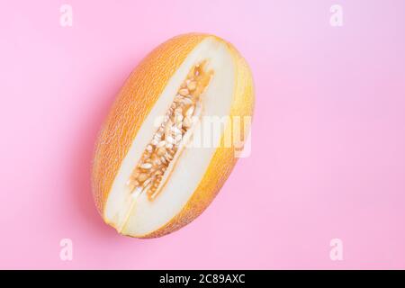 Melon half on orange background. Creative layout made of fresh melon. Flat lay, top view, copy space Stock Photo