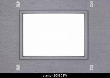 Gray wooden picture frame with blank white poster mock-up on grey painted wood wall. Creative mockup background Stock Photo