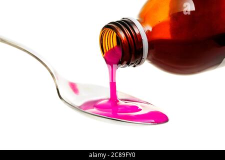 pouring cough or antipyretic syrup on spoon isolated on white Stock Photo