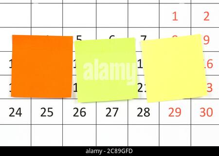 three colorful adhesive notes on calendar Stock Photo