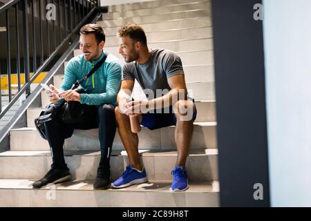 Happy friends enjoying break while chatting in the gym Stock Photo