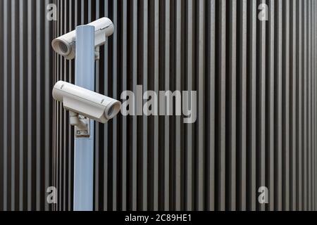 security surveillance cameras against modern urban background Stock Photo