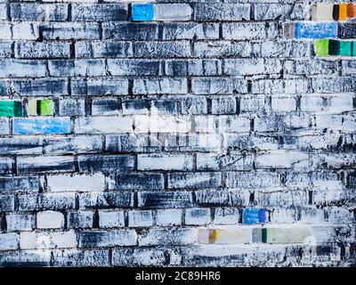 Rough white painted brick wall with colored bricks, textured background Stock Photo